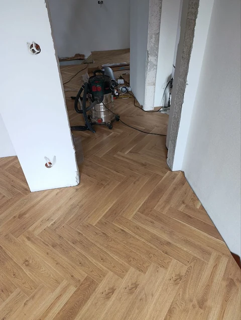 Podłoga w jodełkę przechodząca między pomieszczeniami podczas prac